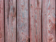 Old plank wooden wall made of boards. Old wooden boards with red nails with peeling paint abstract texture background.