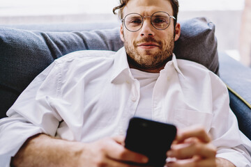 Poster - Close up portrait of positive caucasian hipster guy in optical spectacles for vision correction