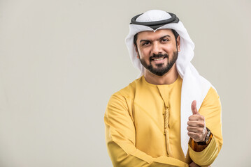 Wall Mural - Arabian man wearing traditional emirati dishdasha kandura in studio - Portrait of middle-eastern male adult with beard