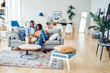 © BullRun - Happy african american young family sitting on sofa in modern designer living room in apartment