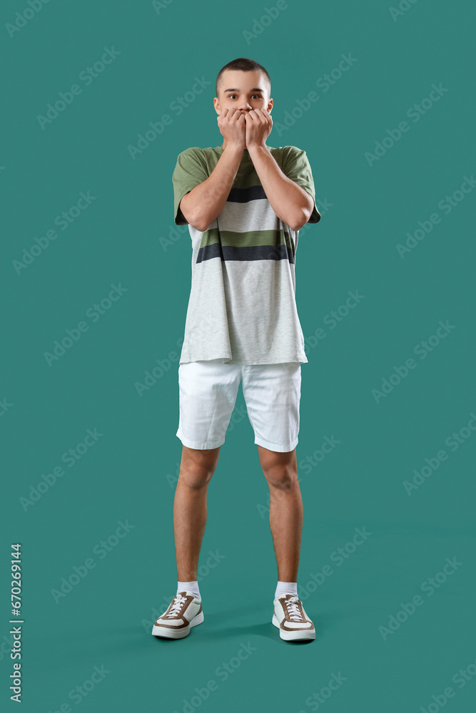 Afraid young man on green background