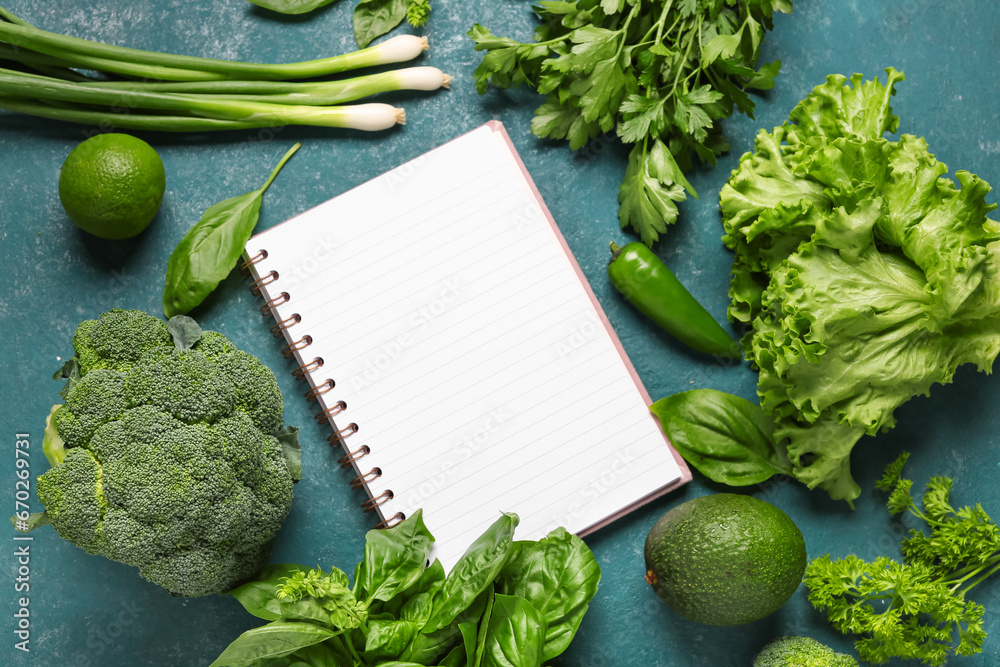 Composition with blank recipe book, fresh herbs and vegetables on color background