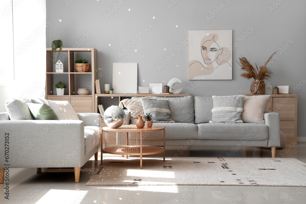 Interior of modern living room with grey sofas and disco ball on coffee table