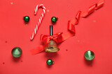 Fototapeta Na sufit - Christmas bell with red bow, balls and candy cane on color background