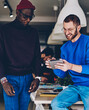 © BullRun - happy hipster guys satisfied with app for booking on touchpad communicating