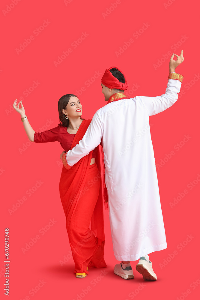 Beautiful Indian couple dancing on red background