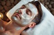 man clay facial mask beauty spa treatment skin male care face mud skincare applying cosmetician natural wellness towel pamper cosmetic beautician people female missy therapy lying brush girl body