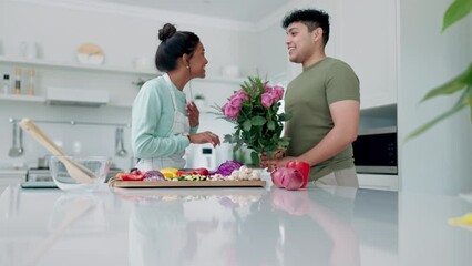 Wall Mural - Cooking, couple and gift with kitchen, flower surprise and food with happy and kiss at home. Smile, young people together and helping with lunch in a house with recipe, ingredients and preparation