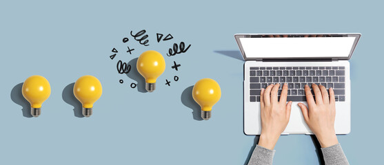 Wall Mural - Idea light bulbs with person using a laptop computer from above