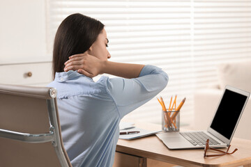 Sticker - Woman suffering from neck pain at table in office