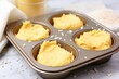 a muffin tin filled with unbaked batter