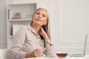 Poster - Woman suffering from neck pain at workplace in room