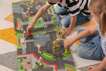 Poster - Little children playing with set of wooden road signs and toy cars indoors, closeup