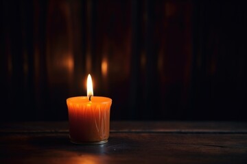 Canvas Print - a single burning candle in a darkened room