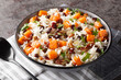 Fragrant rice with sweet potatoes, pecans, onions and dried cranberries close-up in a bowl on the table. Horizontal