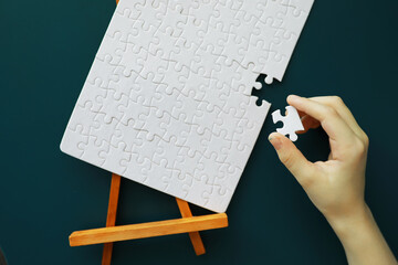 Wall Mural - Intellectual puzzles. The puzzle is empty. The hand puts together puzzle pieces. Brain training.