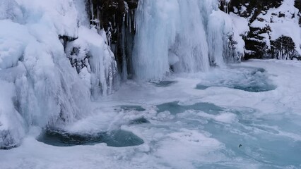 Canvas Print - Kirkjufellsfoss waterfall. Winter landscape. Snow and ice. A popular place to travel in Iceland.