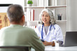 © Kainnika - Senior health care concept. Doctor with patient in medical office. Retired man sits in a hospital examination room while discussing his health with a doctor.