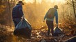 Volunteers collecting garbage in the forest on a sunny autumn day