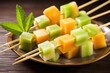 bamboo skewer with cubes of cantaloupe and honeydew