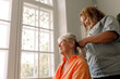 © Maskot - Young female caregiver braiding smiling senior woman's hair at nursing home