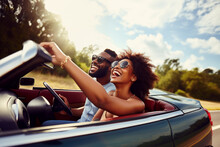 Happy Smiling Young Couple Driving Vintage Cabriolet Car, Going On The Fun Road Trip Together