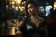 © Sergio - Elegant beautiful African American woman in a restaurant sitting at bar and looking away. Woman in vintage style dress and jewelry