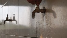 A Man's Hand Is Turning On A Tap Filled With Clean Water