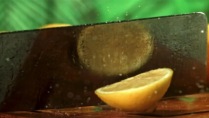 Wall Mural - A knife cuts a lemon on a cutting board. Filmed on a high-speed camera at 1000 fps. High quality FullHD footage