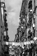 Facade in a narrow street in old town “Centro storico“ of historic italian metropole Naples. Balconys of typical residential building block of flats in rotten and weathered condition, black and white.