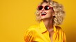 © LaxmiOwl - Blond young happy woman laughing wearing 80s fashion in Stylish woman posing as supermodel on yellow background