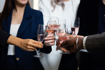 Closeup hand holding glassware. Business people celebrate making a toast on event party at office. Celebration Success Concept