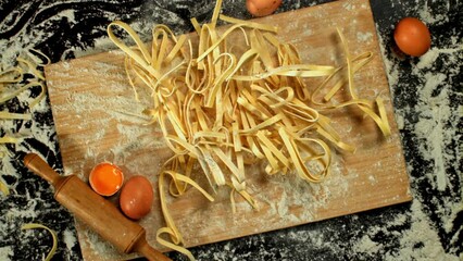 Poster - Homemade fettuccine pasta falls on a cutting board. View from above. High quality FullHD footage