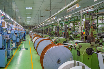 Wall Mural - Elastic weaving workshop at textile factory in industrial zone in Ho Chi Minh City, Vietnam, with modern machinery and technology systems.