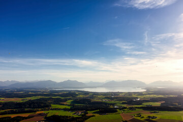 view over Lake Chiemsee to the Alps with clouds and blue sky