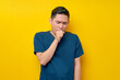 © Bangun Stock Photo - Professional young Asian male doctor or nurse wearing a blue uniform feeling unwell and coughing isolated on yellow background. Healthcare medicine concept