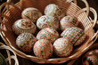 Colorful hand painted Easter Eggs in a wicker bowl. Egg decorating in Slavic culture.