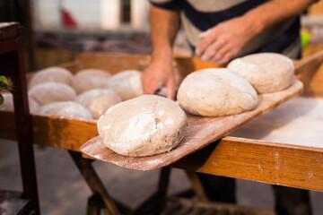 Wall Mural - Wheat dough shaped into loaves arranged in rows on the table before baking