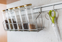 Glass Spice Jars With Spices On A Hanging Metal Shelf.