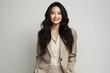 Picture of a pretty Asian lady with long black hair, dressed in a beige suit, feeling happy and looking directly at the camera, set against a white background. Generative AI