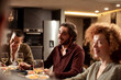 © Marko Geber - Friends sharing smiles and stories over a cozy dinner