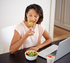 Wall Mural - Eating, salad and woman with laptop, remote work and healthy food or nutrition in home office. Hungry, person and working on lunch break with fruit and vegetables for energy or wellness in house