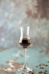 Wall Mural - Coffee liqueur in  stylish grappa glass and coffee beans on the table