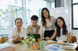 © amnaj - Young asian modern people in smart casual wear having meeting planning work together as a team and present ideas at work.