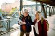 © Davor - Two elderly women share a laugh while holding a map at a train station