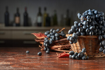 Wall Mural - Blue grapes in old basket on a brown vintage table.