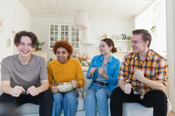 Wall Mural - Group of friends watching sport match soccer football game on tv. Happy football fans celebrating victory at home. Friendship sports entertainment concept. Diverse buddies having fun together at home