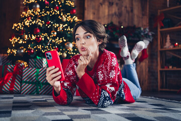 Sticker - Photo of attractive young woman lying floor hold device wondered dressed red sweater christmas room interior design tree decorated indoors