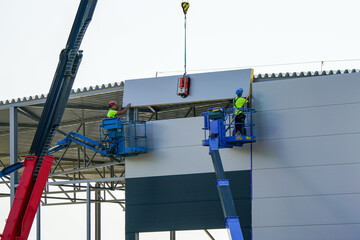 Sandwich panels wall assembly using telescopic boom crane and two self propelled articulating lifts