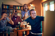 © Geber86 - Elated friends celebrate a thrilling sports moment on TV